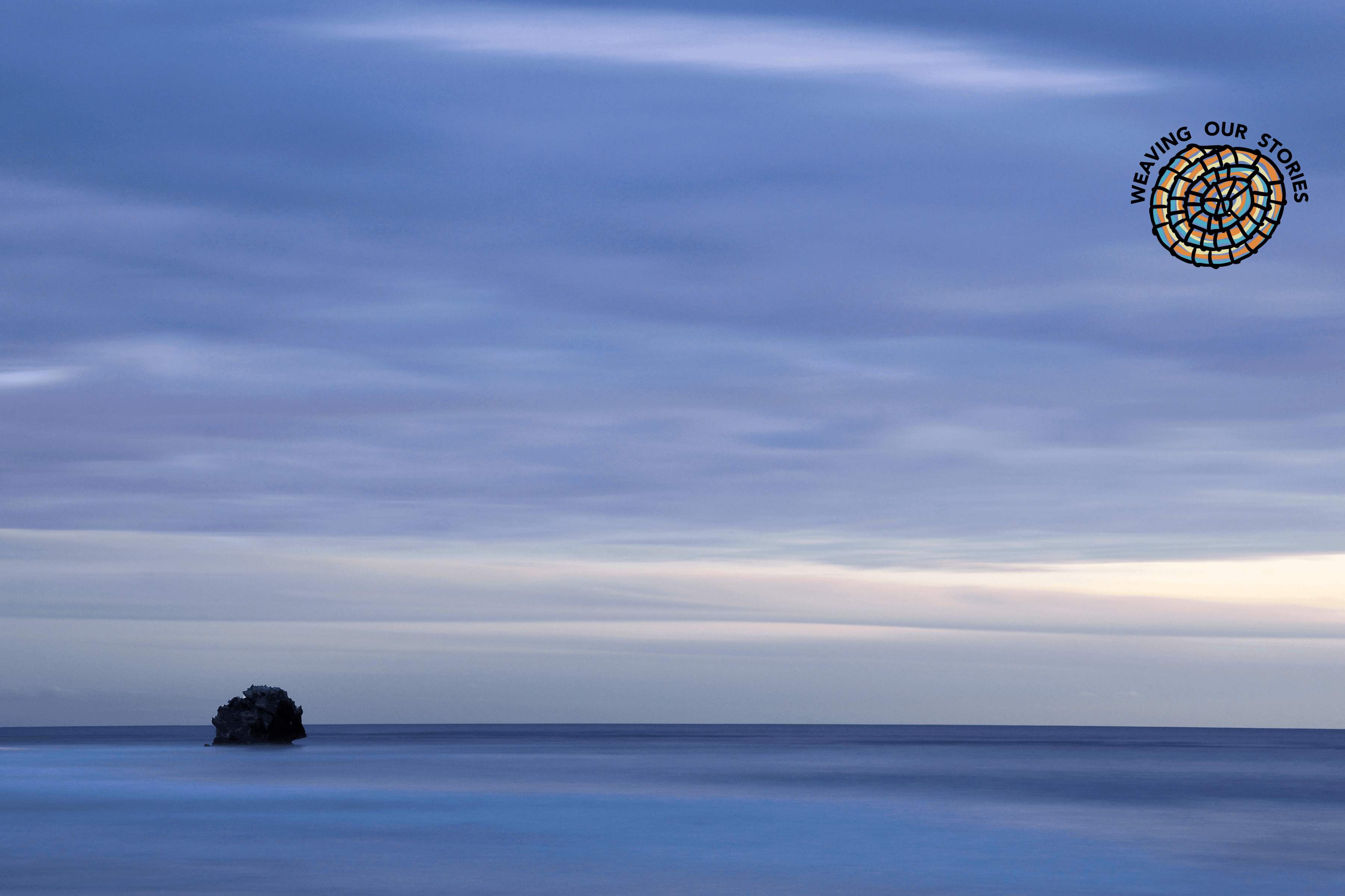 Rock in Open Sea, Two Rocks, Noongar country. Tiffany Garvie. Source: Ngarrngga. © Tiffany Garvie 2023. Used under licence Rock in Open Sea, Two Rocks in Noongar country, blue cloudy skies with the WOS logo in the corner.