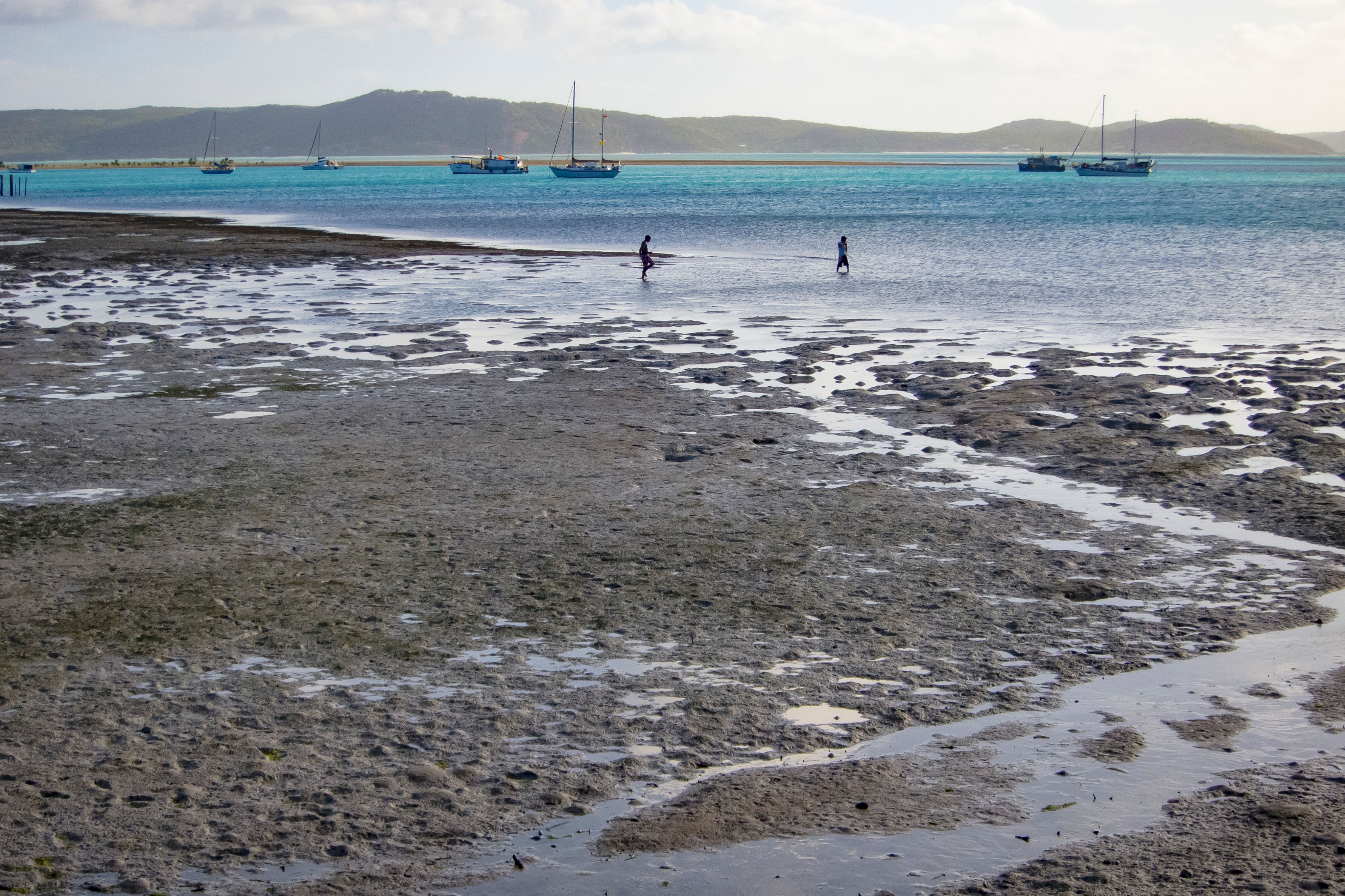 Seascape with anchoring yachts. Thursday Island (Waiben), Torres Strait Islands. Photographer: Uwe Moser. Source: Getty Images. Used under licence. two men walk into water on Waiben (Thursday Island) on the Torres Strait Islands