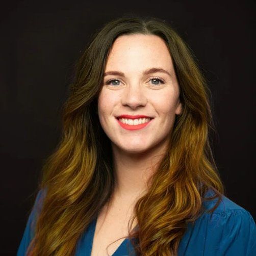 Dr Abbey MacDonald, Senior Academic Fellow IMAGE Dr Abbey MacDonald in front of black background wearing blue shirt