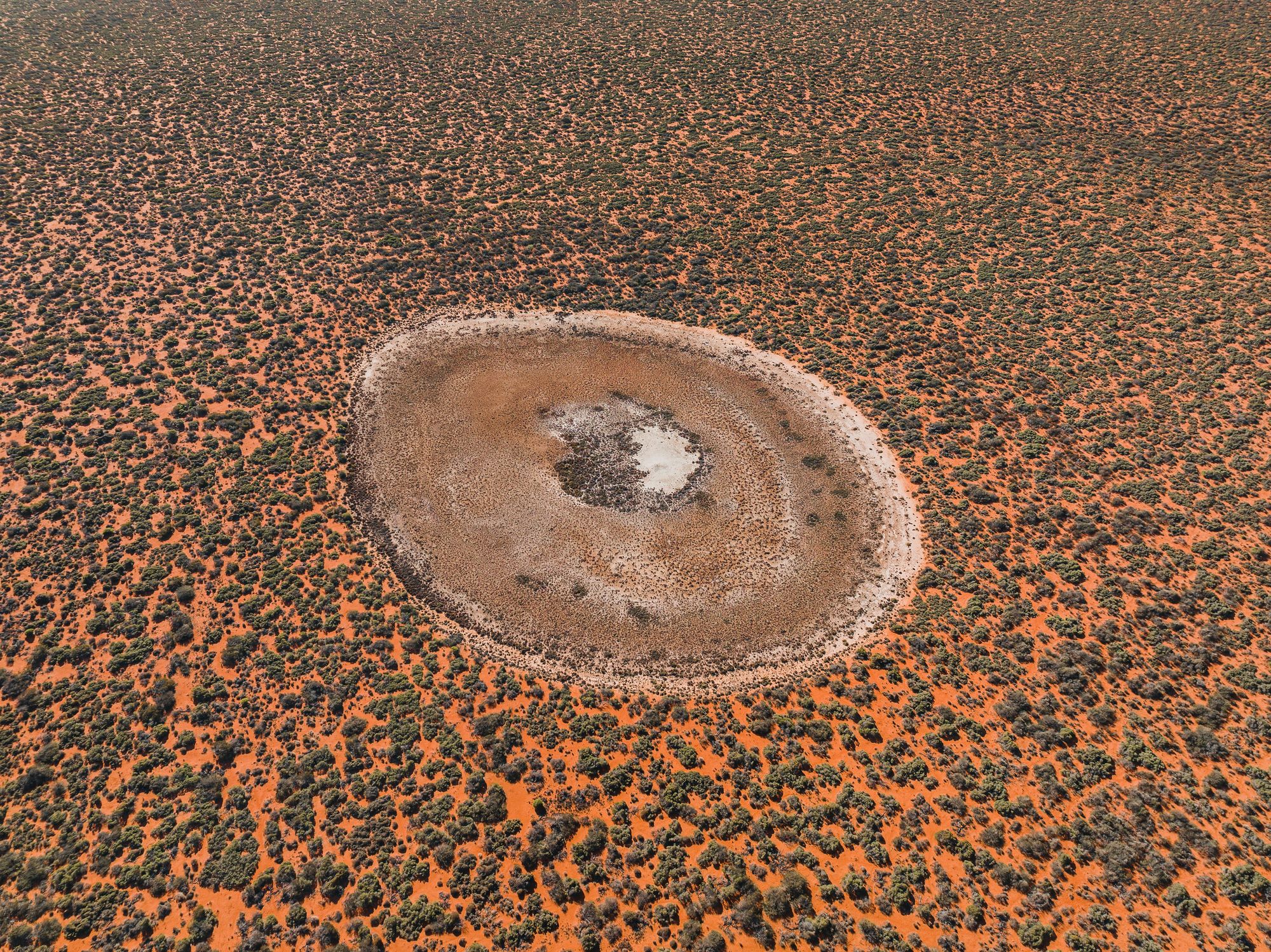 Impact crater in the Australian outback. Photographer: Francois Peron. Source: Getty Images. Used under licence. Impact crater in the australian outback shot from aerial perspective.