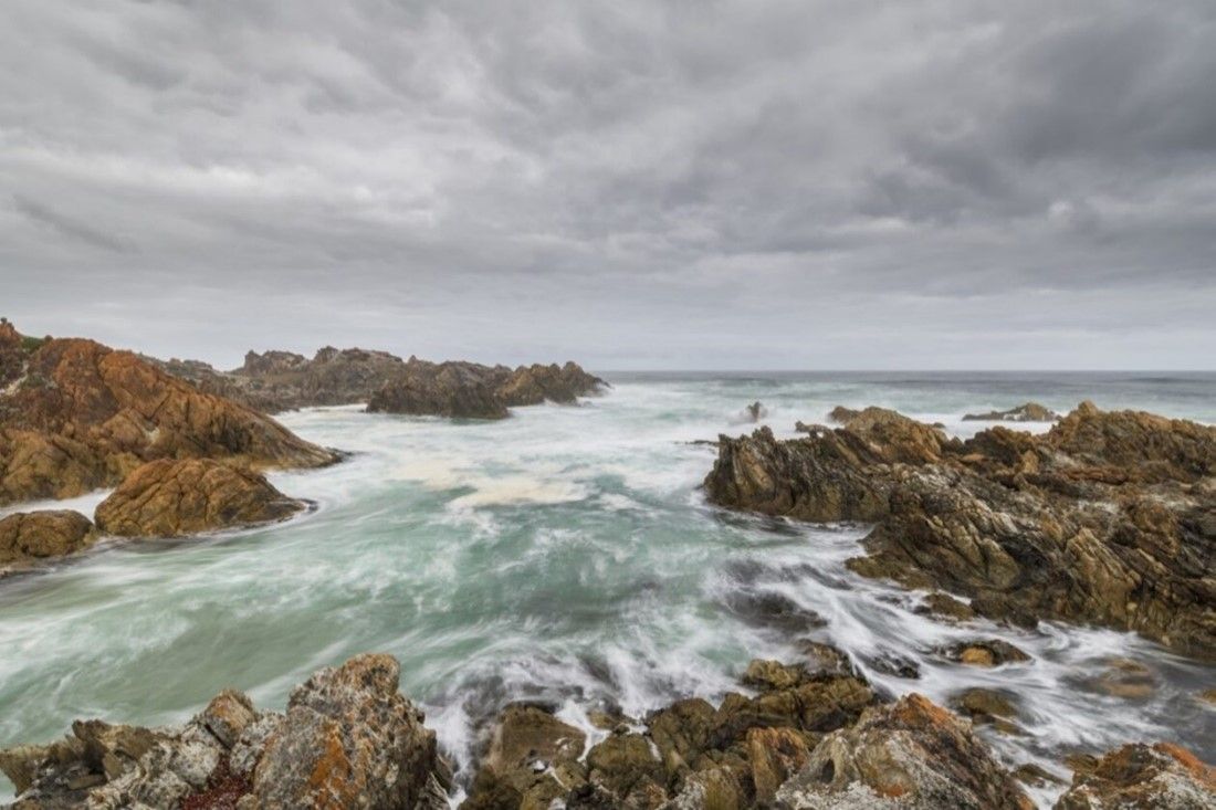 Ocean waves wash around a rocky headland