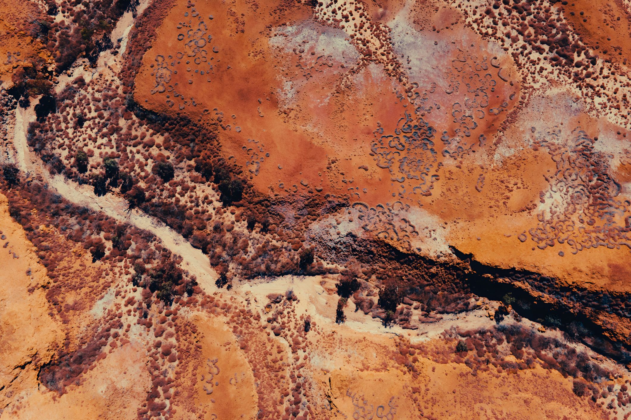 Aerial View of Desert Terrain With Red Rocks and Dirt Textures & Patterns. Pilbara Region, Western Australia. Photographer: Swift Hound Media. Source: Getty Images. Used under licence. Aerial View of Desert Terrain With Red Rocks and Dirt Textures & Patterns.