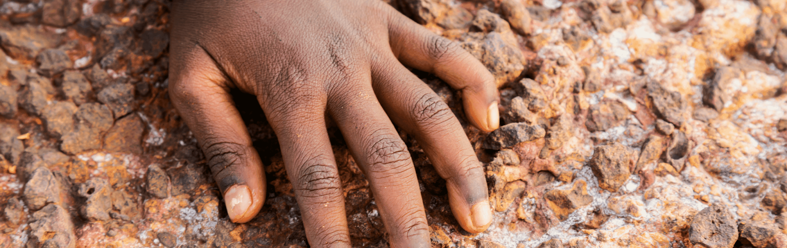 A child's hand along a rock face