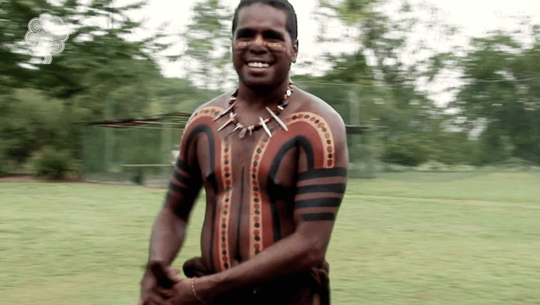 Man with traditional body paint smiles at camera
