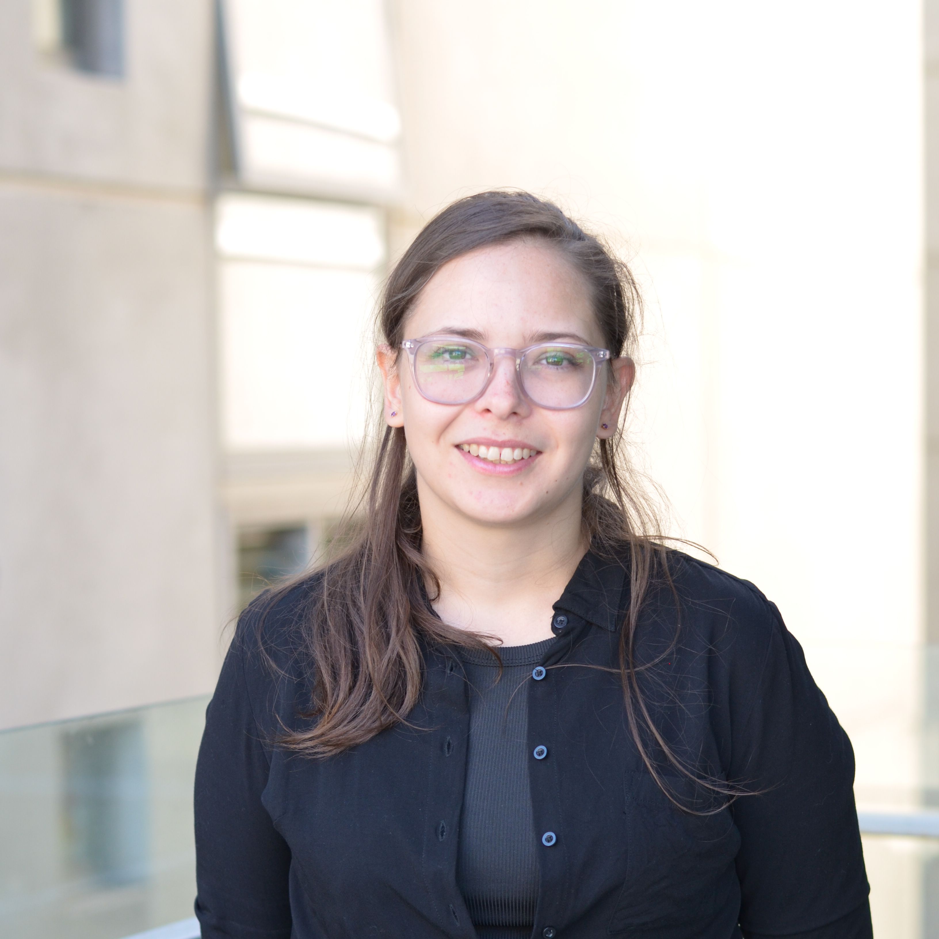 Emily Gittins, Digital / Graphic Designer IMAGE Emily Gittins in black shirt outside the Faculty of Education