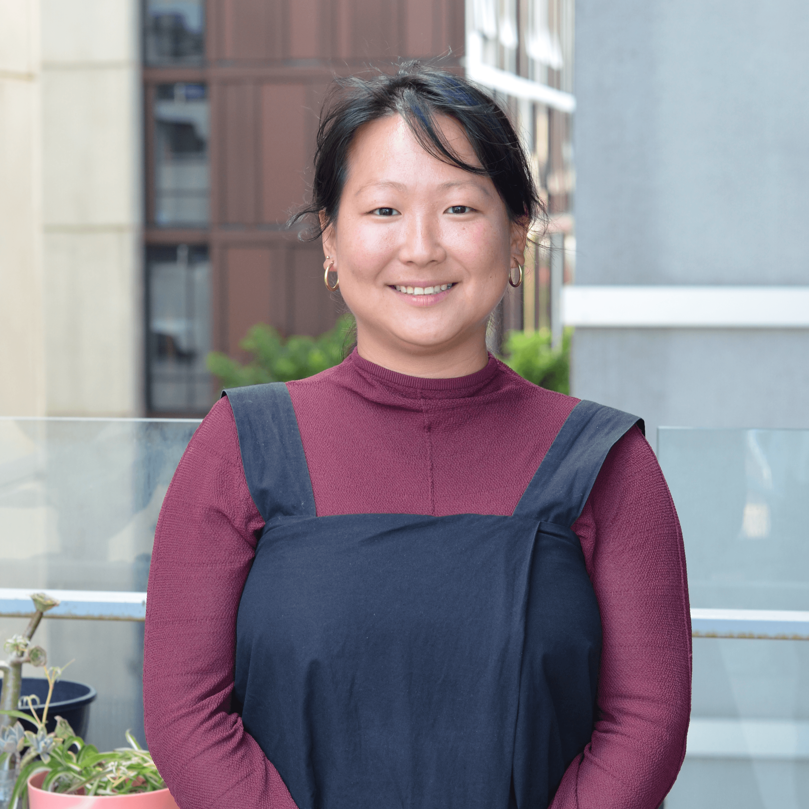 Sara Tajima Headshot Sara Tajima in a red long sleeve and pinfore outside the faculty of education at melbourne university