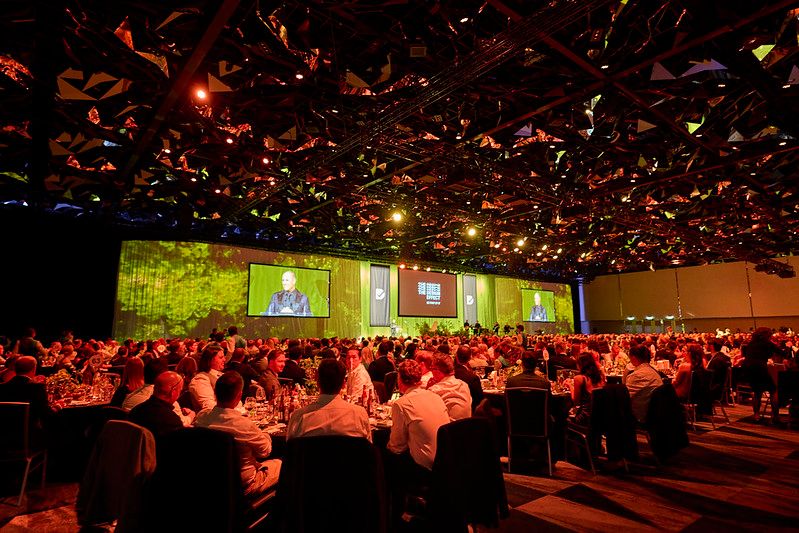 Good Design Awards Image Good Design Awards, audience bathed in red light with presenter on stage and on screen